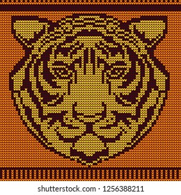 Knitted tiger head pattern on orange background in frame
