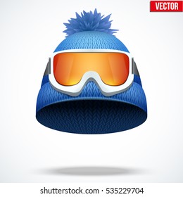 Knitted woolen cap with snow ski goggles. Winter seasonal sport hat. Vector illustration isolated on white background.