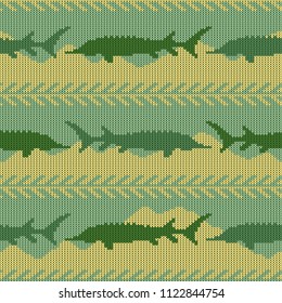 Knitted woolen seamless pattern with sturgeons. Yellow sand and green water