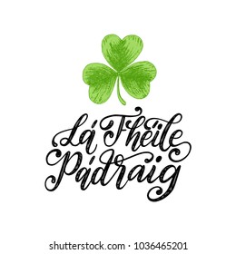 La Fheile Padraig translated from Irish Saint Patrick's Day handwritten phrase for greetings card or poster. Calligraphy with drawn image of clover leaf. Irish festive vector illustration.