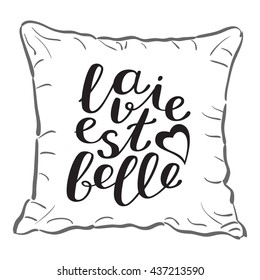 La vie est belle, life is beautiful in French. Brush hand lettering on a sample throw pillow. Great for pillow cases, posters, photo overlays, home decor and more.