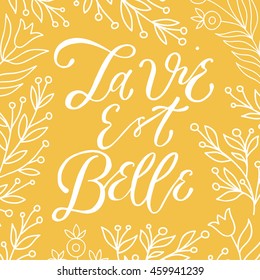 la vie est belle life is beautiful lettering  poster with floral branches, typography poster, hand calligraphy, calligraphy positive phrase on a yellow background