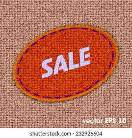 label in the form of a patch on a fabric background with the text of sale