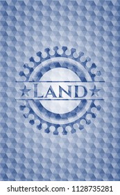 Land blue emblem or badge with abstract geometric pattern background.