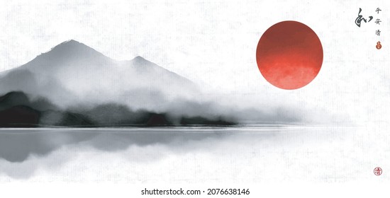 Landscape wtih big red sun and misty mountains reflecting in water on rice paper background. Traditional ink painting sumi-e, u-sin, go-hua. Hieroglyphs - peace, tranquility, clarity, harmony.