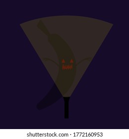 lantern shining from below illuminates a scary ghost in the shape of a banana with red triangular eyes and sharp fangs the concept of the autumn holiday and mysticism an object against a dark initial 