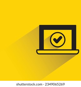 laptop and check mark with shadow on yellow background