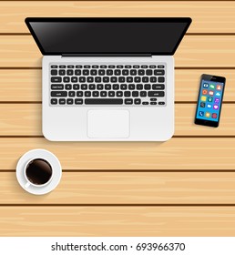 Laptop with cup of coffee and smartphone on wooden table