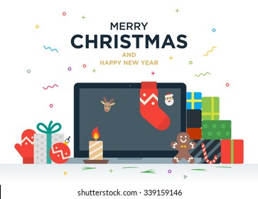 Laptop with gifts, candles, red ball and Christmas socks on the screen. Christmas postcard with greeting text