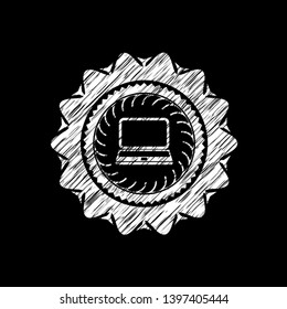 laptop icon inside chalk emblem written on a blackboard