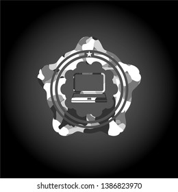 laptop icon inside grey camouflaged emblem