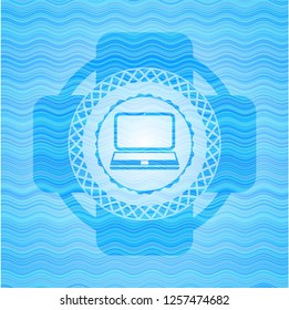 laptop icon inside light blue water wave emblem background.
