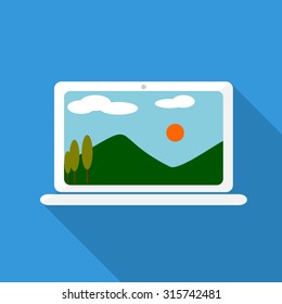 Laptop on blue background, with landscape in monitor