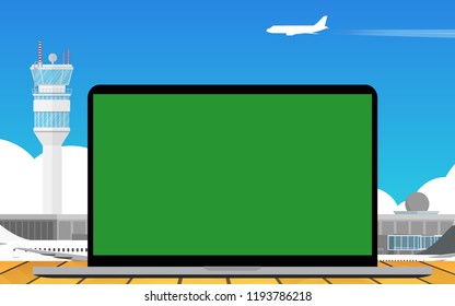 Laptop on the wooden table surface with landscape view of airport terminal with airplane in the airport in the background 