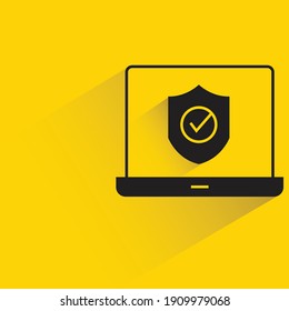 laptop and shield security concept drop shadow on yellow background