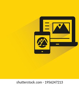 laptop and smartphone with banner shadow on yellow background