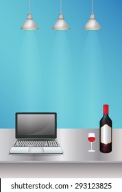 laptop and wine on a steel table with lamp light