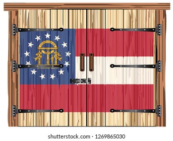 A large closed wooden barn double door with bolt and hinges and the Georgia flag painted on