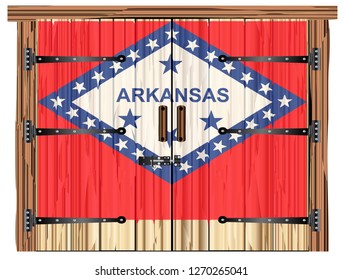 A large closed wooden barn double door with bolt and hinges and the Arkanas flag painted on