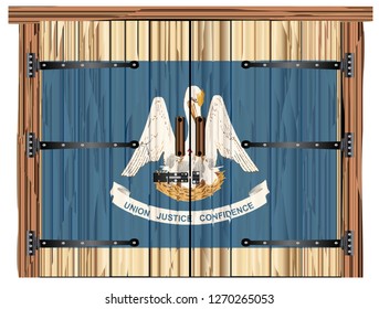 A large closed wooden barn double door with bolt and hinges and the Louisiana flag painted on