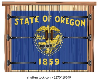 A large closed wooden barn double door with bolt and hinges and the Oregon flag painted on