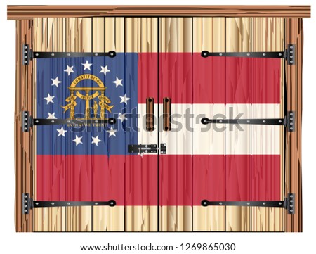 A large closed wooden barn double door with bolt and hinges and the Georgia flag painted on
