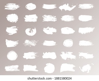 Large collection of strokes, brushes, lines, roughness of white color isolated on beige background. Modern textured shapes. Straight brush strokes. Vector illustration.