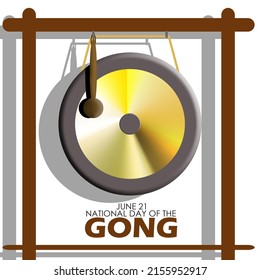 A large gong hanging between a wooden assembly with bold texts on white background, National Day of the Gong June 21