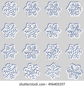 Large set of white paper snowflakes with a blue drop shadow on gray background