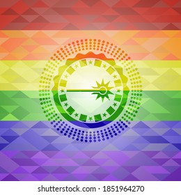 icono láser dentro del emblema sobre fondo de mosaico con los colores de la bandera LGBT. 
