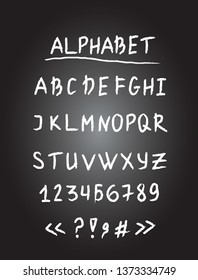 latin chalk alphabet lettering on black background . 