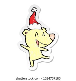 laughing bear hand drawn distressed sticker cartoon of a wearing santa hat