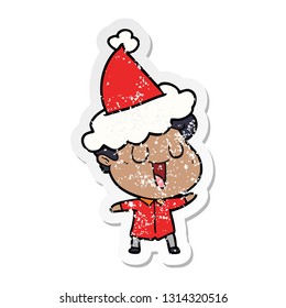 laughing hand drawn distressed sticker cartoon of a man wearing santa hat