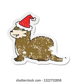 laughing otter hand drawn distressed sticker cartoon of a wearing santa hat