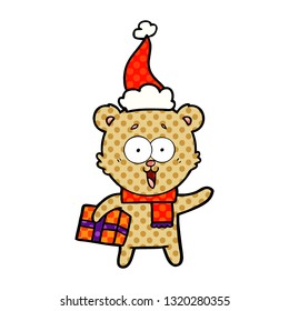 laughing teddy  bear with christmas present wearing santa hat
