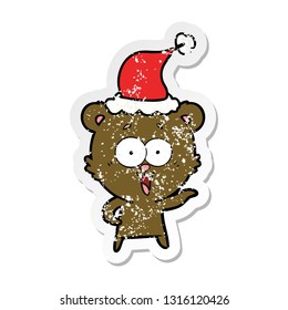 laughing teddy  bear hand drawn distressed sticker cartoon of a wearing santa hat