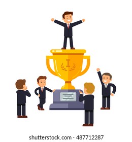 Leader standing on big winner golden cup pedestal spreading his hands in triumph gesture. Business crowd applauding supporting and praising man at the top. Modern flat style vector illustration.