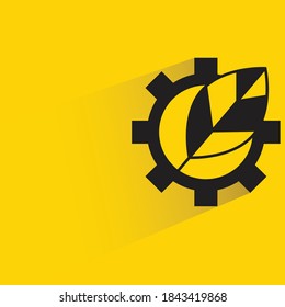 leaf and gear drop shadow on yellow background