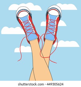 legs in sneakers on the background of the sky with clouds. funky colored shoes gumshoes fashion sneakers isolated.