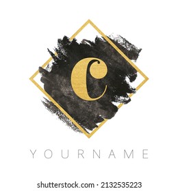 Diseño del logotipo de la letra C. Razo del pincel de color de agua negro con letra dorada y marco cuadrado dorado.