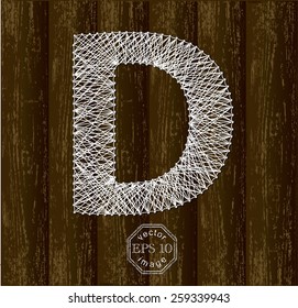 Letter D, made with white threads on pins