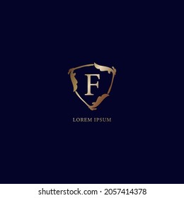 Letter F Alphabetic logo design template isolated on navy blue background. Decorative floral shield sign illustration. Luxury metallic gold security logo concept. 