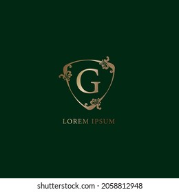 Letter G Alphabetic logo design template. Luxury gold decorative floral shield sign illustration isolated on dark green background. Insurance logo concept