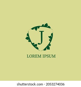Letter J alphabetic logo design template. Nature Guard, Security logo concept  isolated on green beige color. Decorative floral shield sign illustration. 