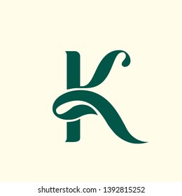 Letter K logo.Initial lettering icon with green leaves.Stylized typographic sign isolated on light background.Modern, clean, cosmetics, food, health and nature boutique alphabet character shape.