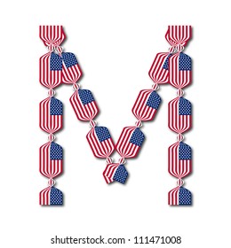 Letter M made of USA flags in form of candies on white background