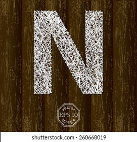 Letter N, made with threads on pins on wooden background. Part of collection.