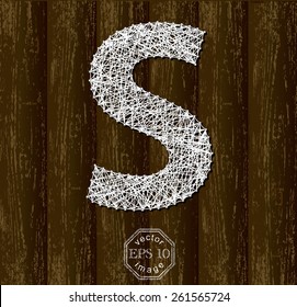 Letter S, made with threads on pins on wooden background. Part of collection.