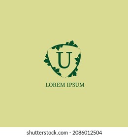 Letter U alphabetic logo design template isolated on green beige color. Decorative floral shield sign illustration. Nature Guard, Security logo concept. 