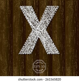 Letter X, made with threads on pins on wooden background. Part of collection.